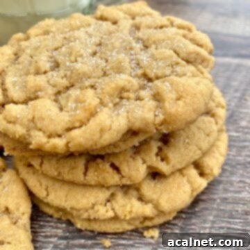 Grandma's Chewy Peanut Butter Cookies 11 A stack of perfectly golden old-fashioned chewy peanut butter cookies next to a tall glass of milk, a classic comforting snack.