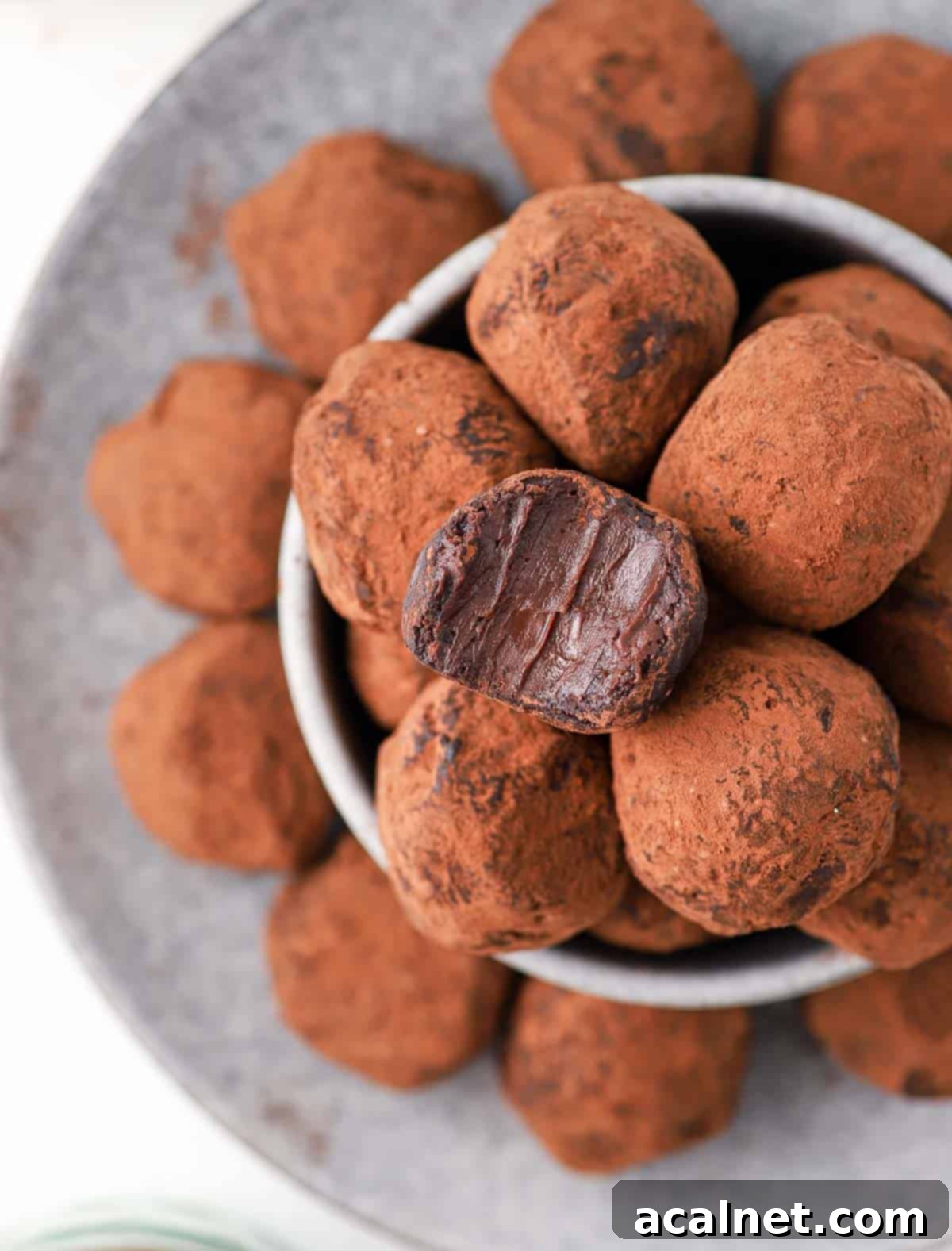 Chocolate balls seen from above stacked in a grey bowl.