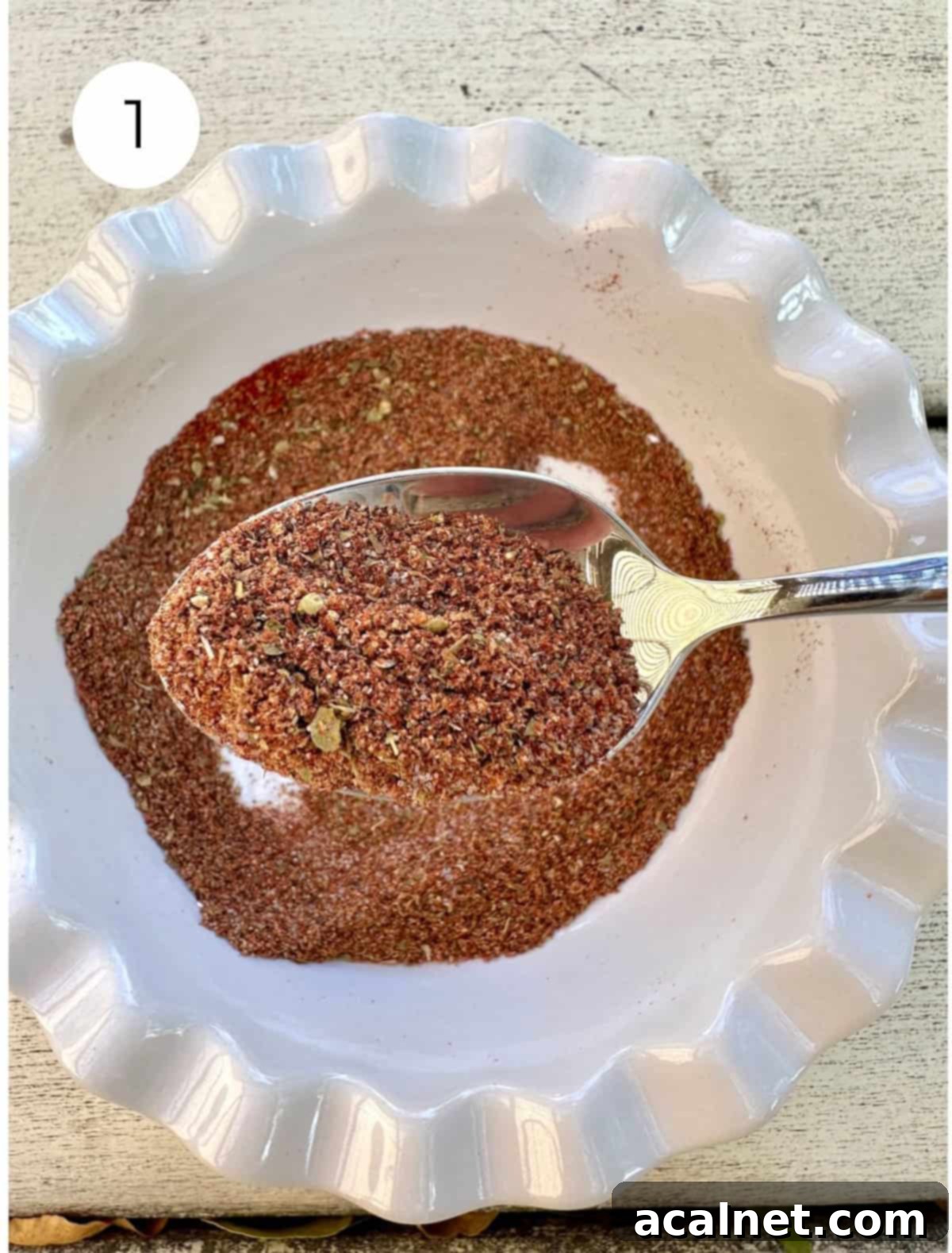 Blended seasoning in a small bowl with a spoon, showing the perfectly mixed spice blend.