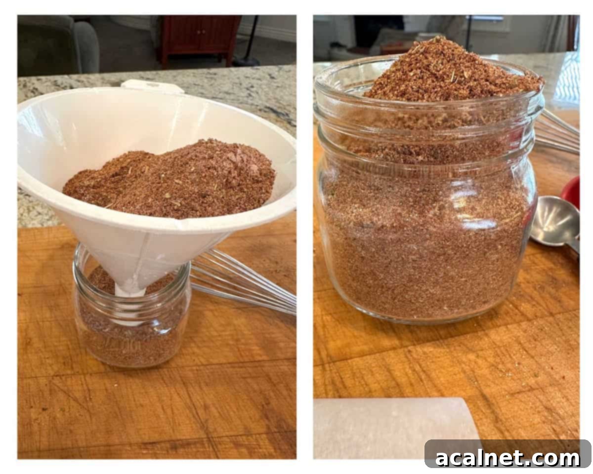 A funnel being used to pour taco seasoning into a jar, with another filled jar beside it.