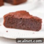 Molten French Chocolate Fondant Cake 9 Close up on a chocolate fondant cake slice on a white plate.