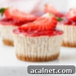 Close up on a mini strawberry cheesecake, perfectly portioned and ready to be enjoyed, placed on a grey serving tray.