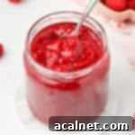Easy 3 Ingredient Raspberry Compote 9 Spoon sticking out of the raspberry compote jar.