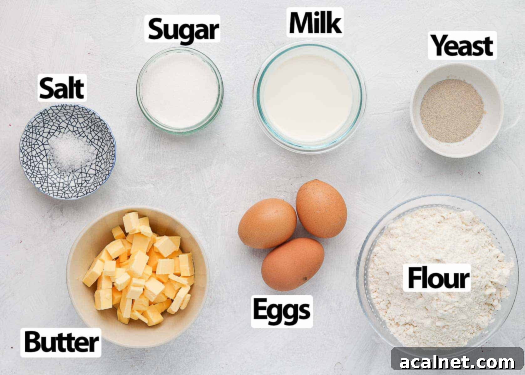 A collection of fresh ingredients laid out on a white surface, ready for brioche preparation.