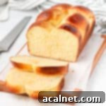 Brioche loaf sliced on a wooden board.