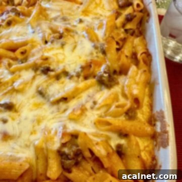 Layered pasta with beef, sauce, and melted cheese in a baking dish, indicating a finished Lazy Lasagna.