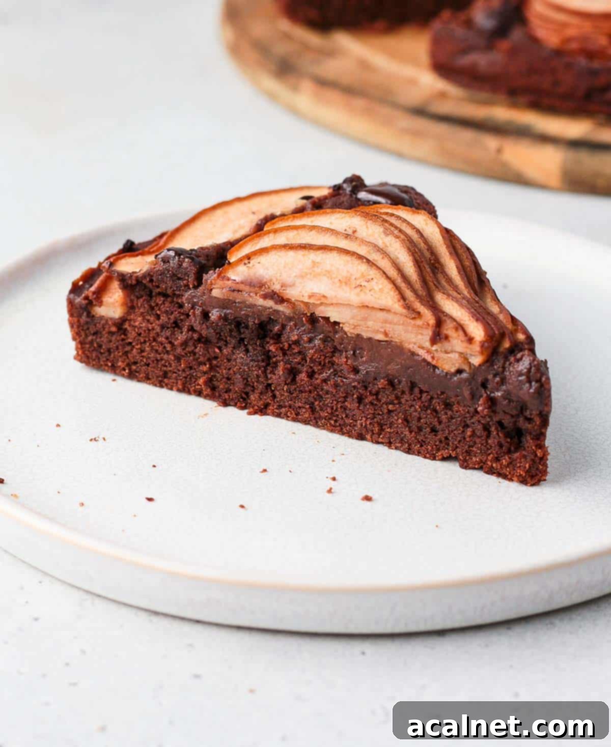 A single slice of Chocolate Pear Cake elegantly presented on a white plate, ready to be enjoyed.