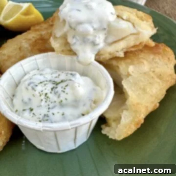 Homemade tartar sauce served in a small cup with a side of crispy fried fish.