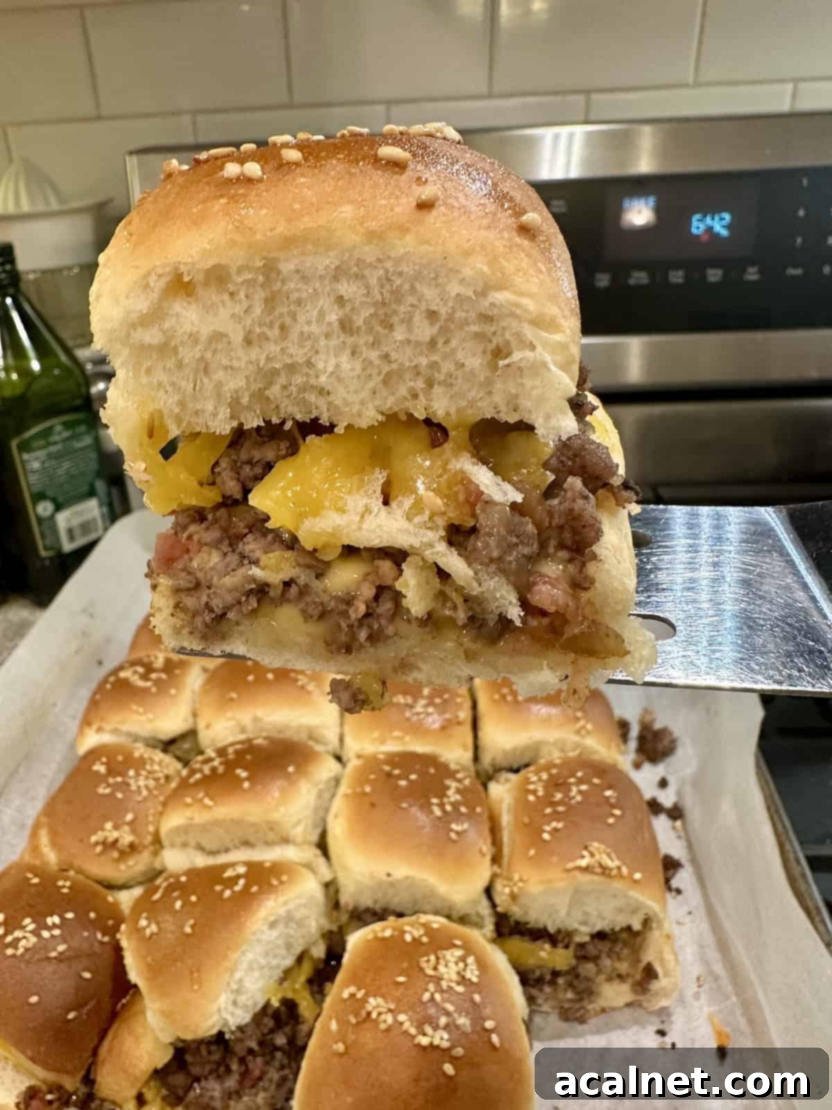 A spatula serving a cheeseburger slider.