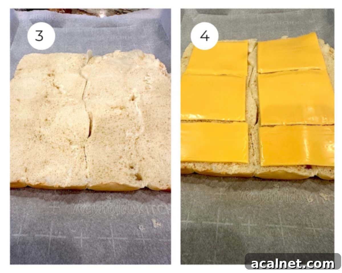 Hawaiian rolls halved on a baking sheet and with sliced cheese on top.