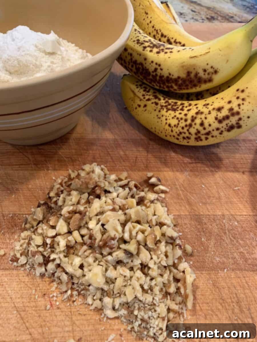Chopped walnuts, ripe bananas and a bowl on a cutting board.