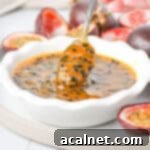 Effortless Passion Fruit Coulis 10 Dipping a spoon in the bowl of passion fruit coulis.