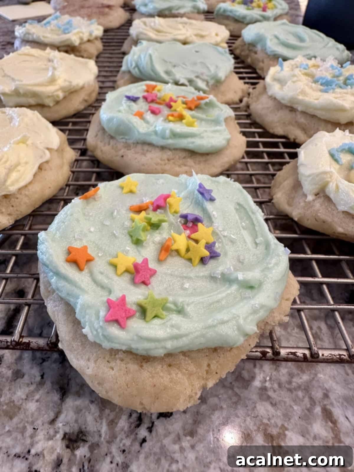 Frosted cookies on a cooling rack.