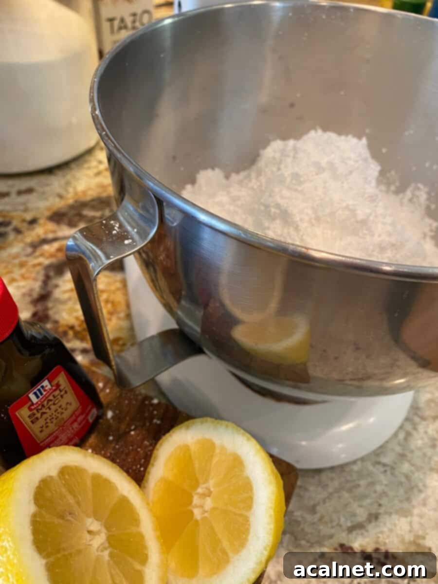 Sliced lemon next to a mixer full of powdered sugar.