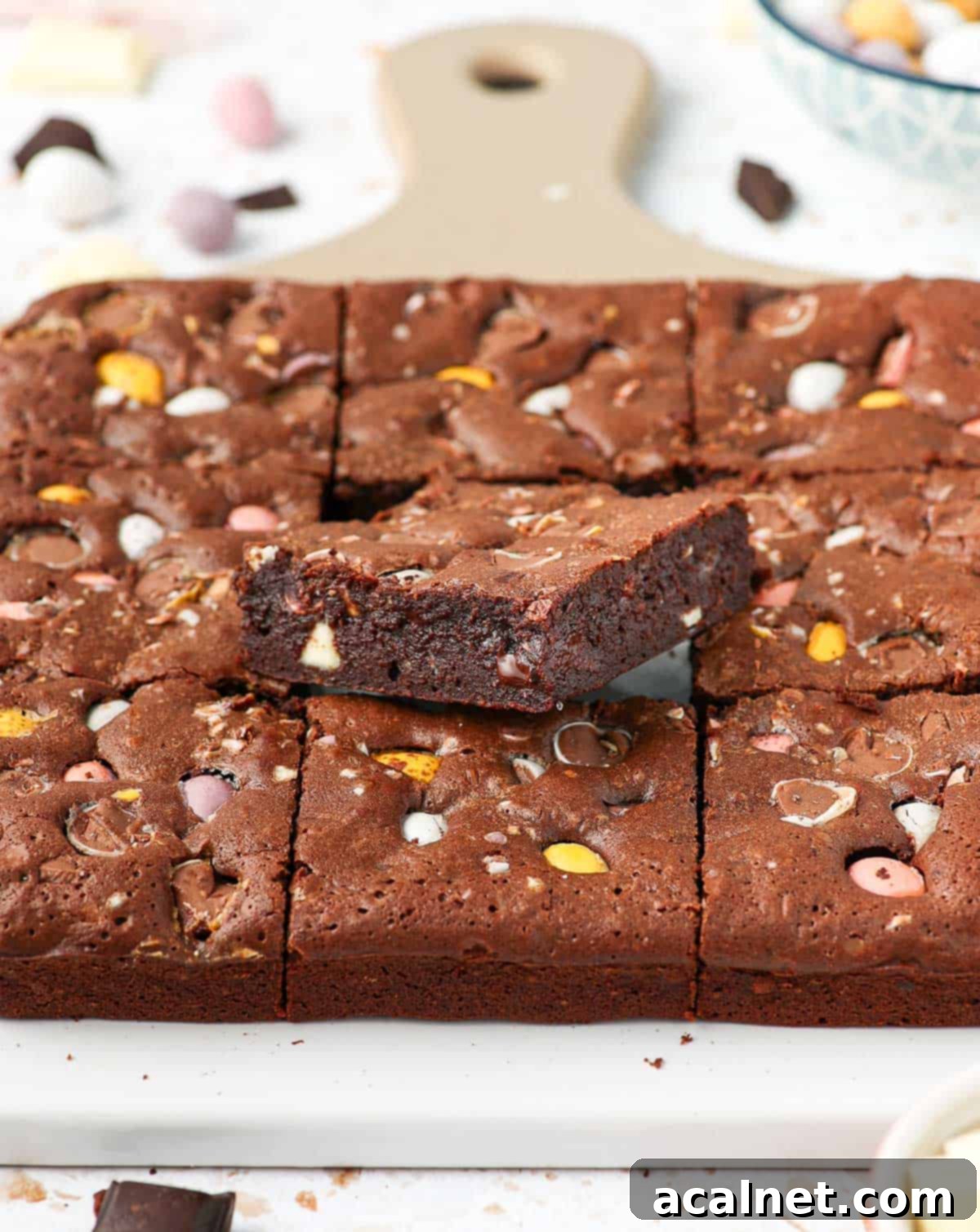 Brownies on a white and beige serving board.