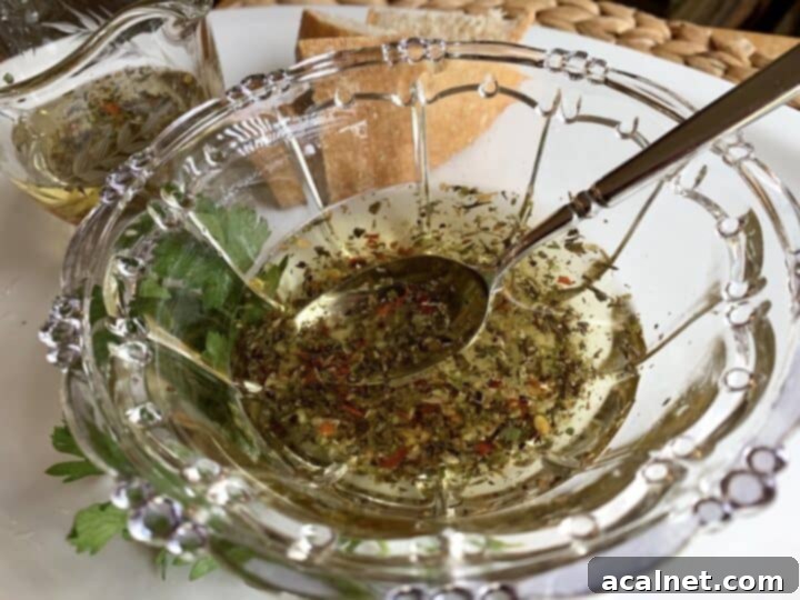 Dipping oil in a bowl on a plate with fresh herbs and bread slices.