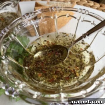 Dipping oil in a small bowl, garnished with fresh herbs, ready to serve.
