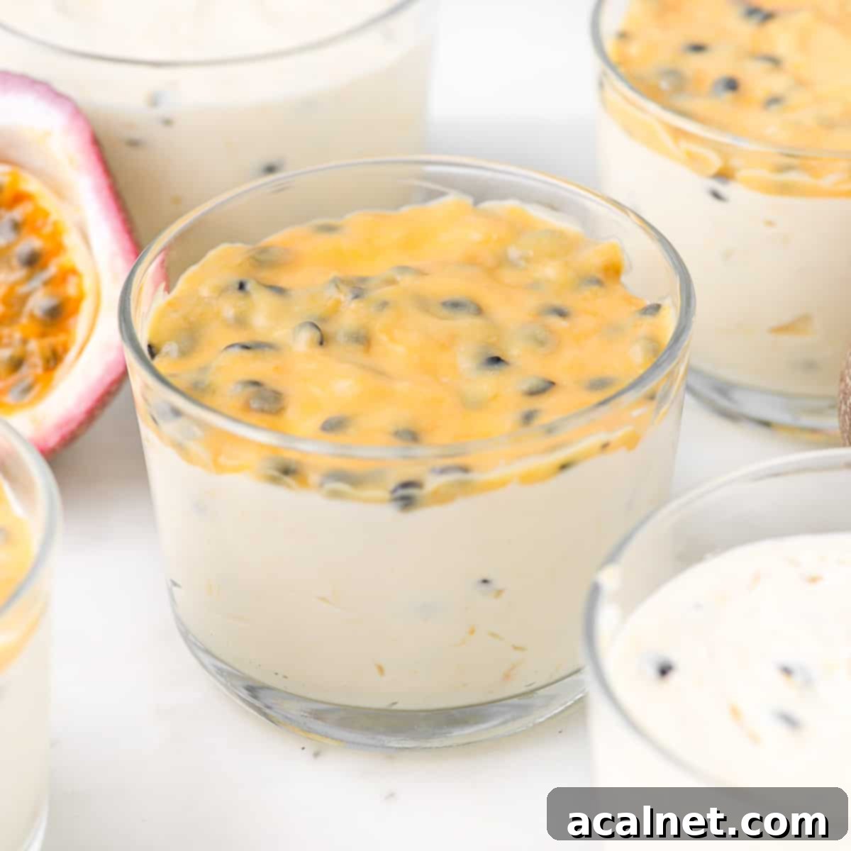 Simple Passion Fruit Cloud 2 Close up on individual mousse cups garnished with fresh passion fruit halves, showcasing the vibrant yellow and a creamy, airy texture of the easy passion fruit mousse.