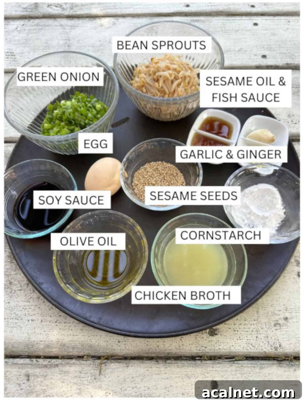 Labeled ingredients for spring roll in a bowl laid out on a cutting board, ready for cooking.