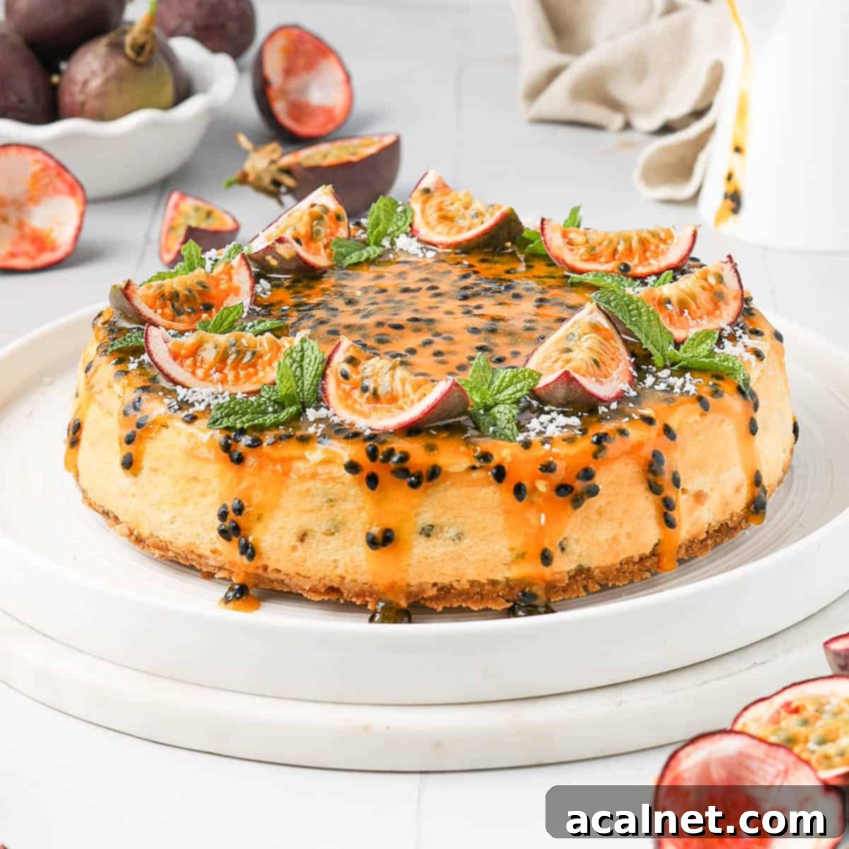 Two slices of passion fruit cheesecake on white plates, garnished with fresh passion fruit halves. Additional passion fruits are scattered in the background, hinting at the fresh ingredients used.