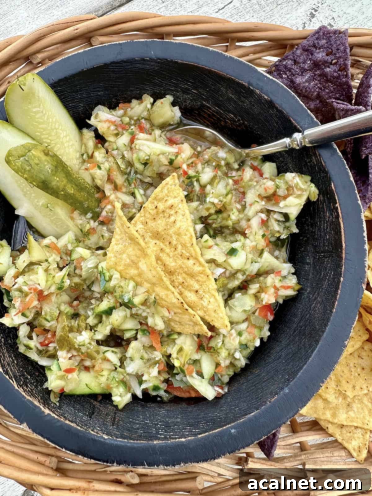 A charming bowl of pickle de gallo nestled in a rustic basket of tortilla chips, ready for sharing.