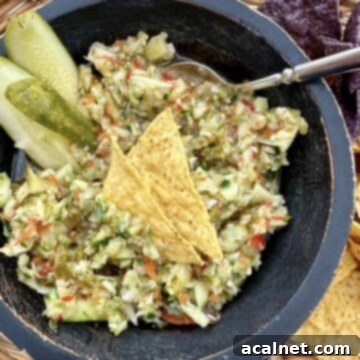 A bowl of vibrant pickle de gallo in a rustic basket of chips, ready for dipping.