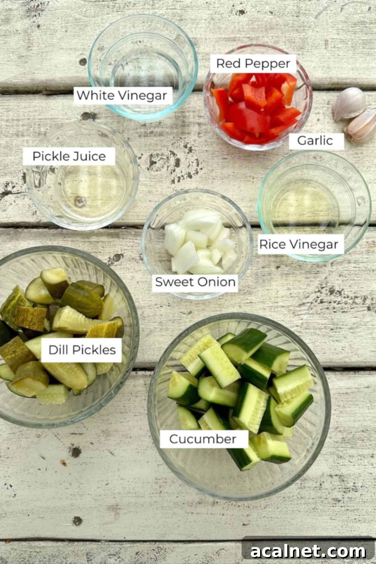 A beautiful display of fresh ingredients for Pickle de Gallo laid out in bowls on a rustic wooden table.