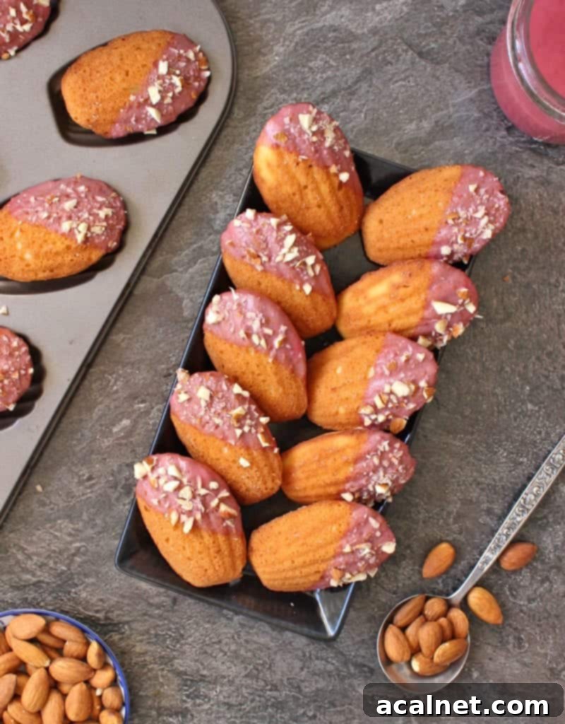 Cakes placed on a black rectangular plate next to the madeleine pan