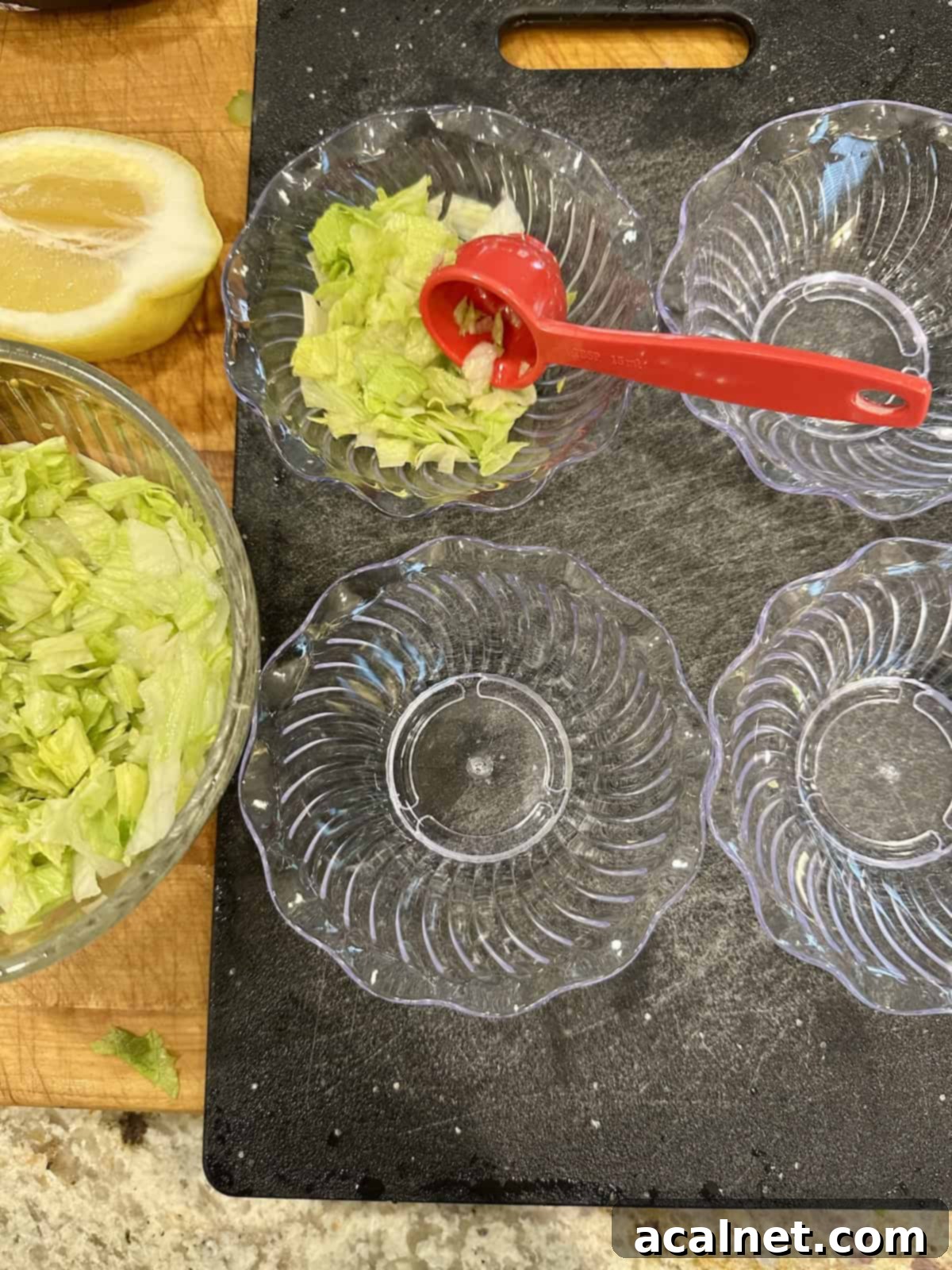 Shrimp Cocktail Shooters 5 Small serving bowls with chopped lettuce added to one of them.