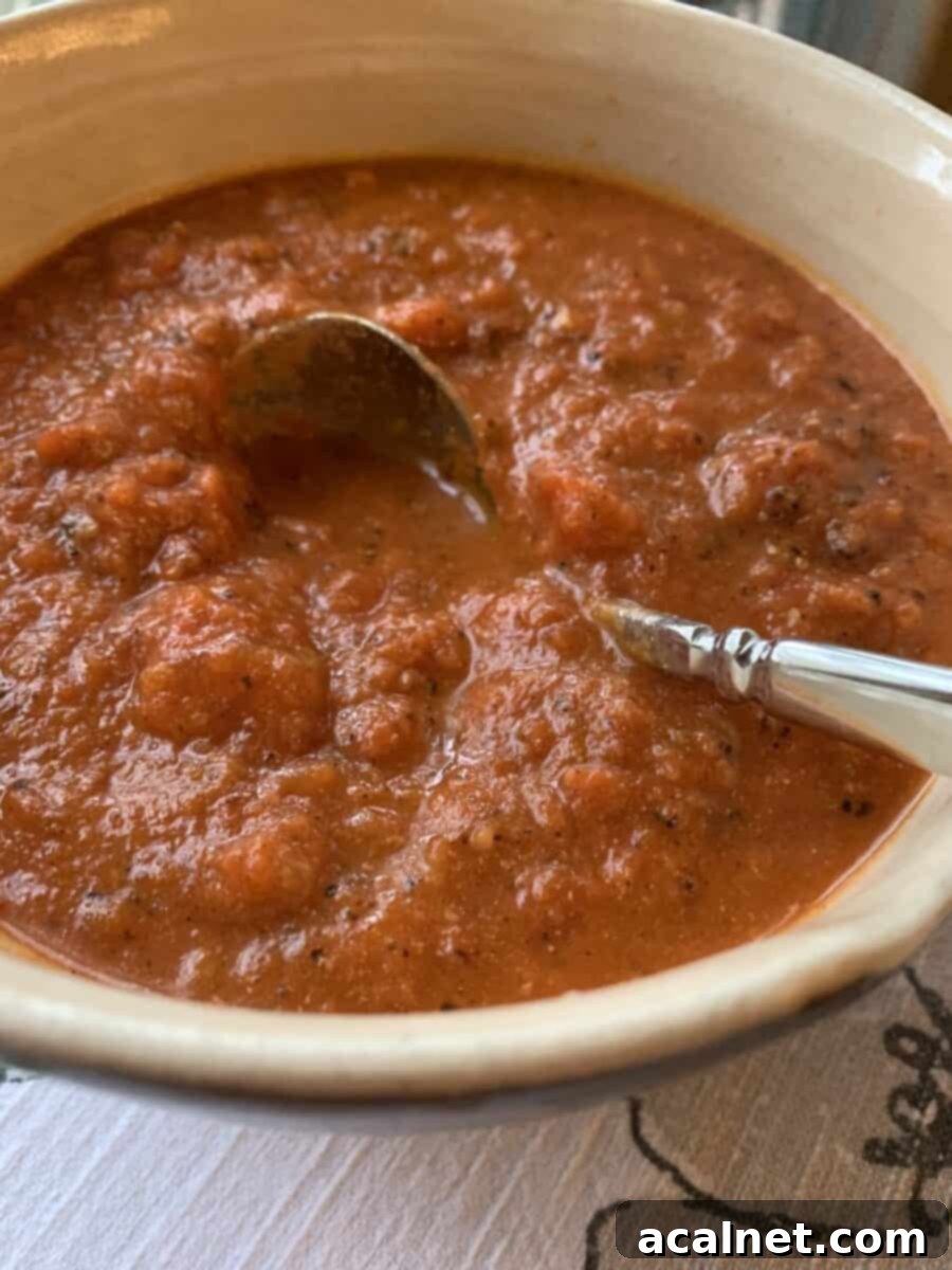 A small, elegant white bowl filled with creamy, vibrant tomato-cream sauce, showcasing its smooth and thick consistency, ready for serving.