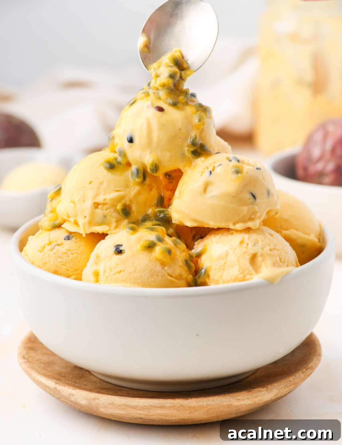 Pouring fresh passion fruit pulp over the ice cream.