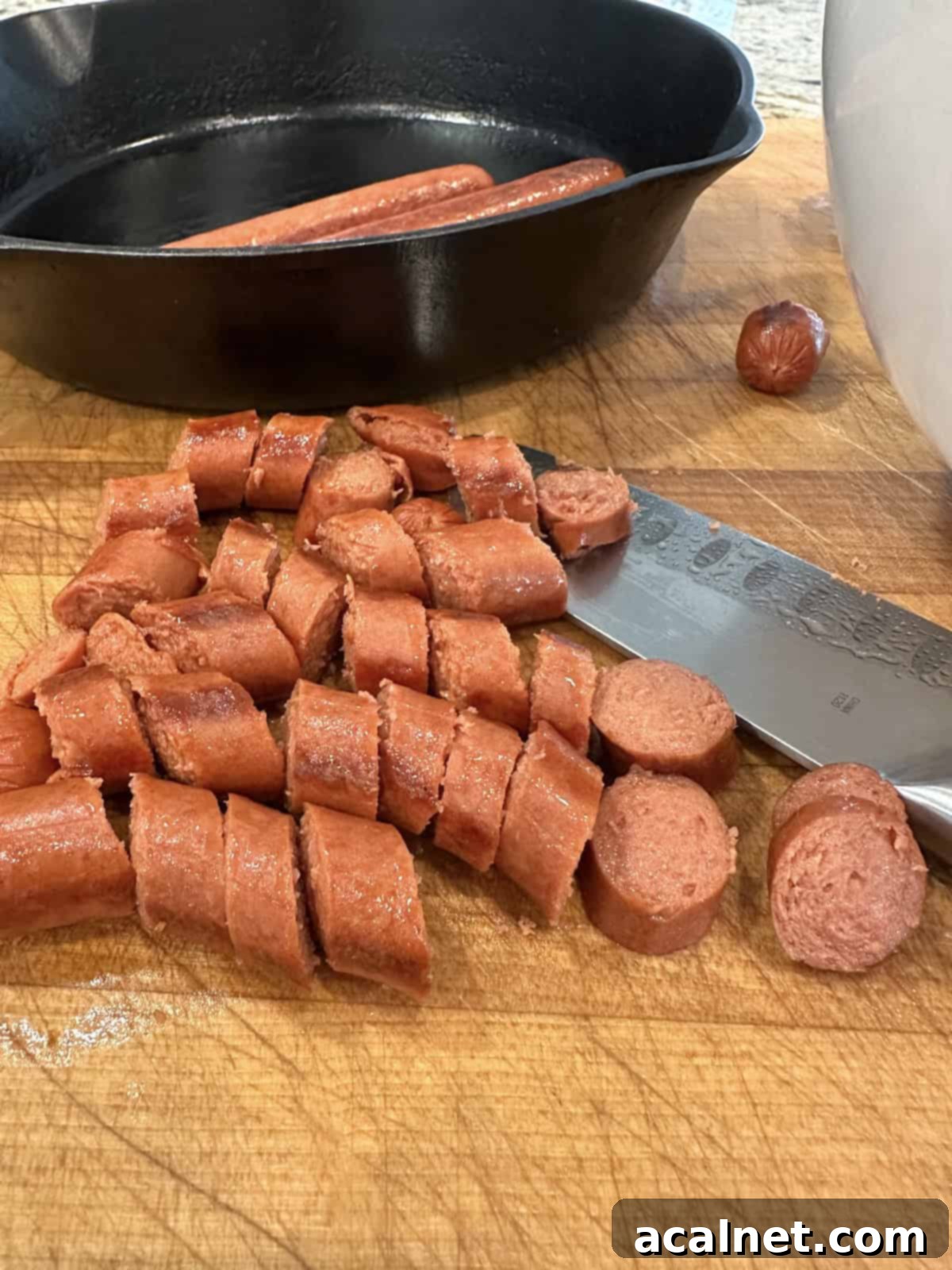 Diced hotdogs on a cutting board, ready to be added to the beans.