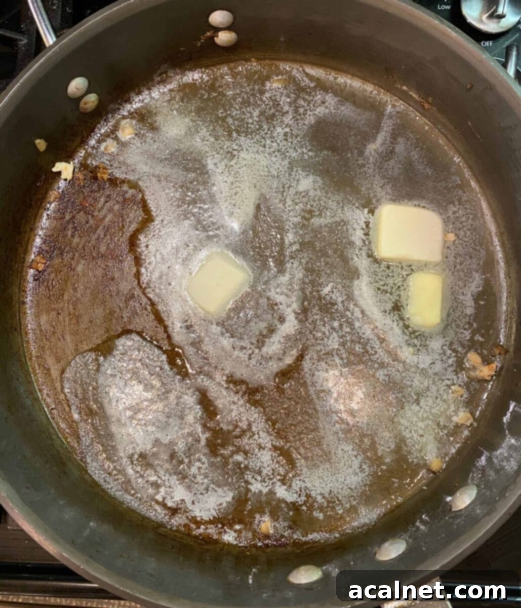 Butter melting in a hot skillet on the stove.