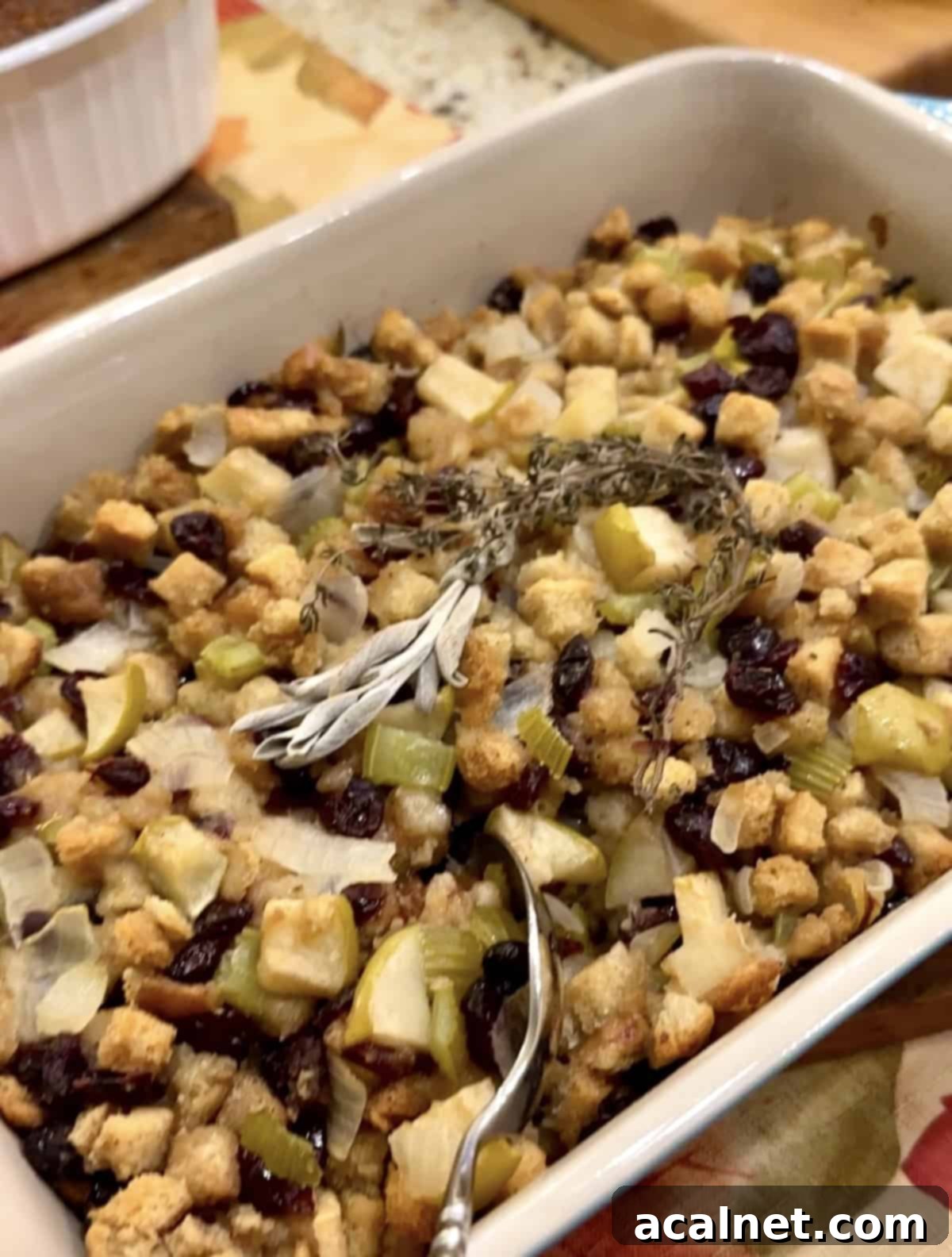 Sweet and Savory Cranberry Apple Stuffing 2 Thanksgiving stuffing recipe, golden brown and garnished with fresh herbs.