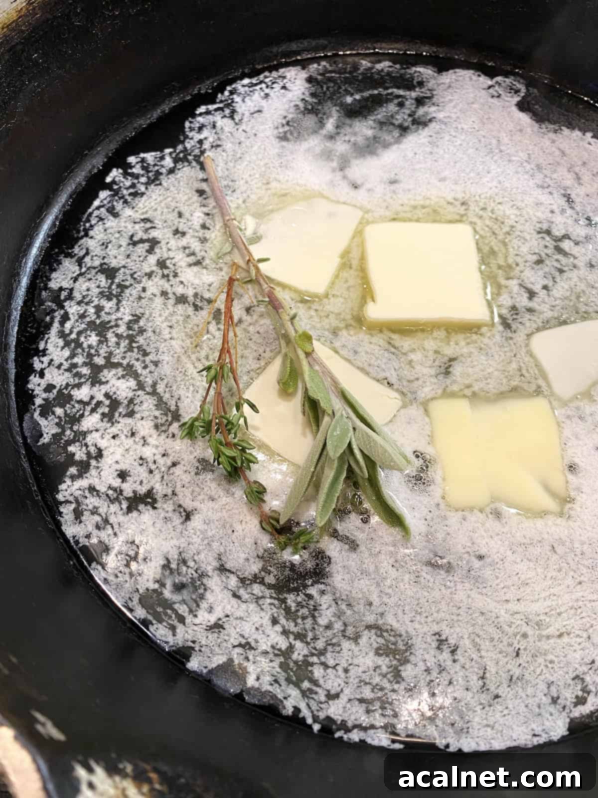 Sweet and Savory Cranberry Apple Stuffing 6 Butter melting in a frying pan with fresh sprigs of sage and thyme infusing.