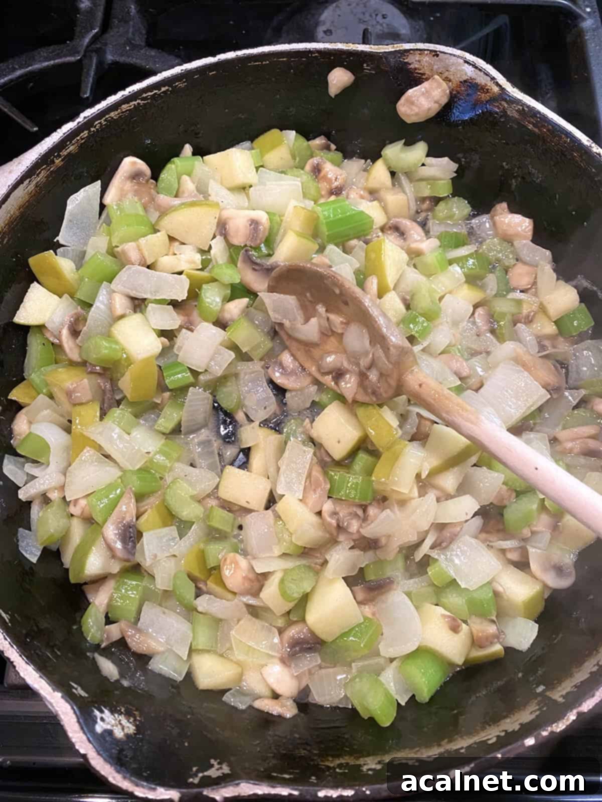 Sweet and Savory Cranberry Apple Stuffing 8 A skillet filled with softened vegetables, apples and mushrooms.