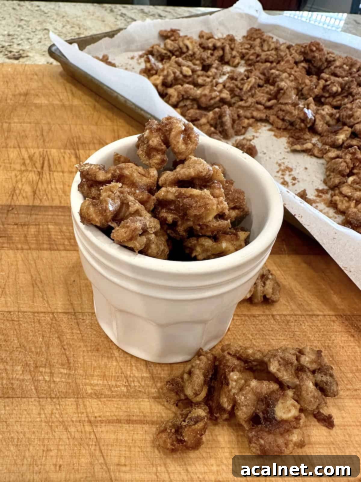 Spiced walnuts on a cutting board, with some in a small jar, ready for serving or gifting.