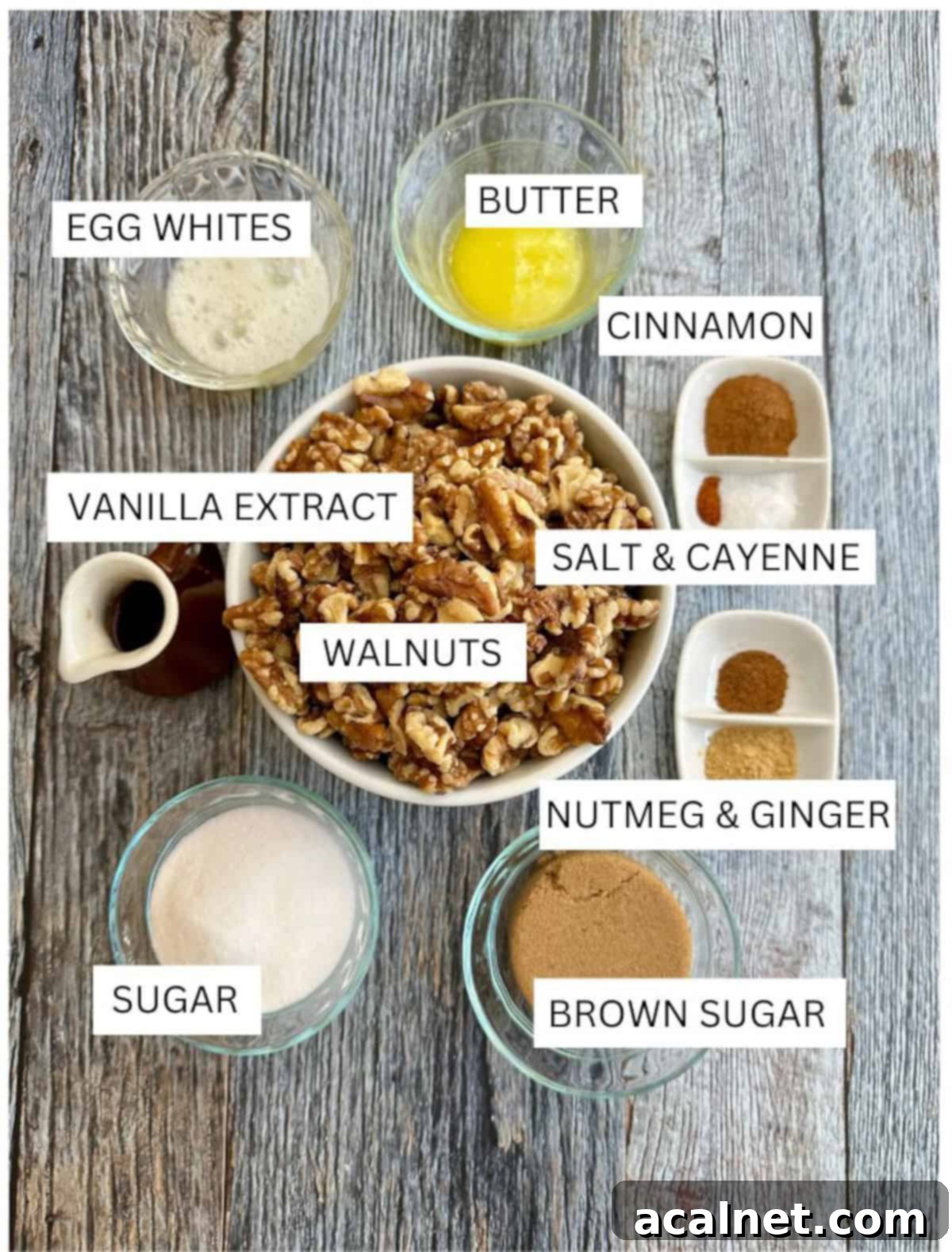 Ingredients for spiced walnuts in small dishes on a wooden table, including walnuts, spices, sugar, and butter.