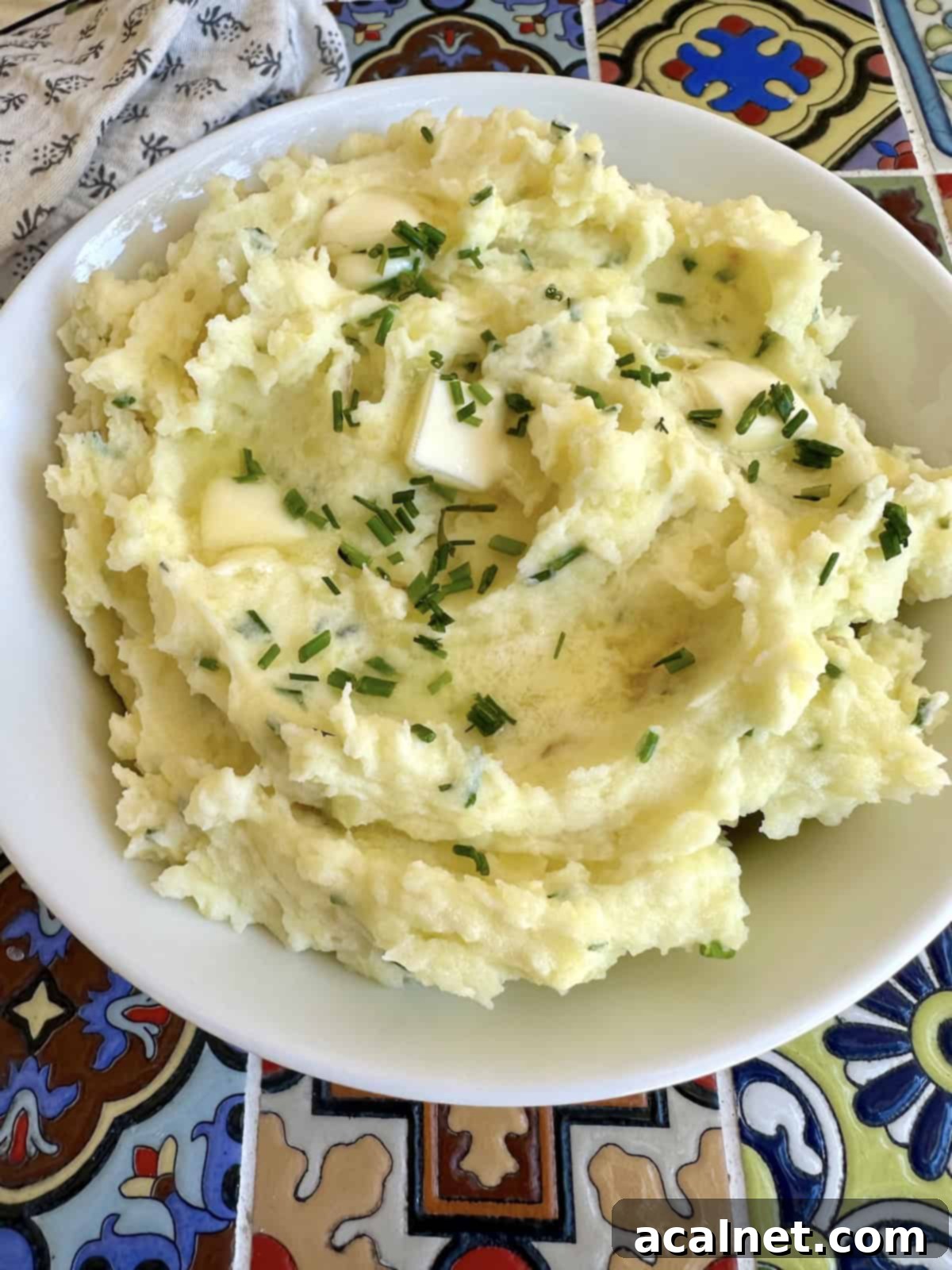 Close-up shot of creamy Yukon Gold mashed potatoes in a rustic bowl, showing off their smooth texture and golden color.