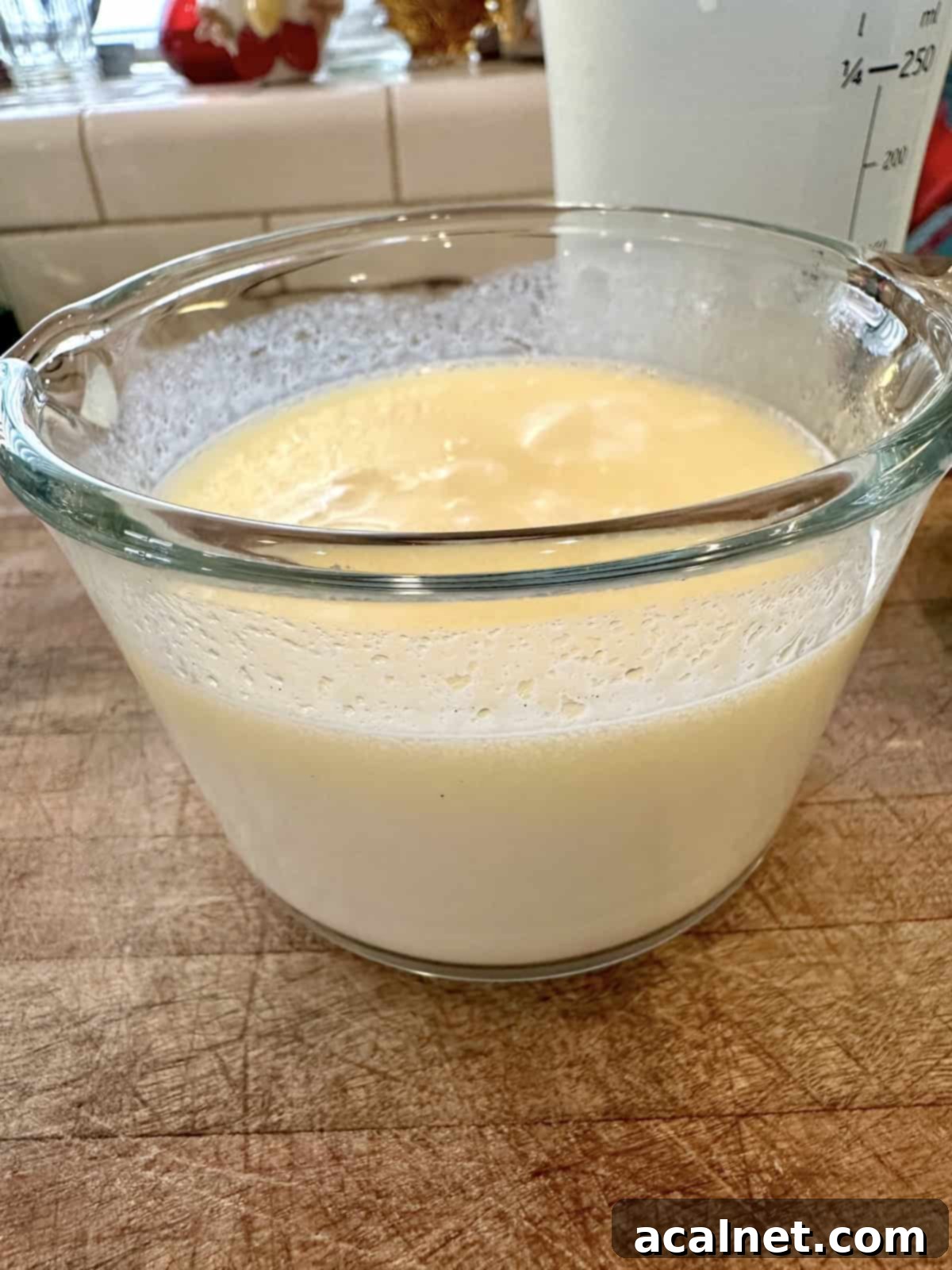 Melted butter combined with potato water and milk in a clear glass measuring cup.