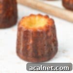 Bordeaux Cannelés 9 Close up on a perfectly baked Cannelé on a white surface, showcasing its golden-brown, crispy exterior.