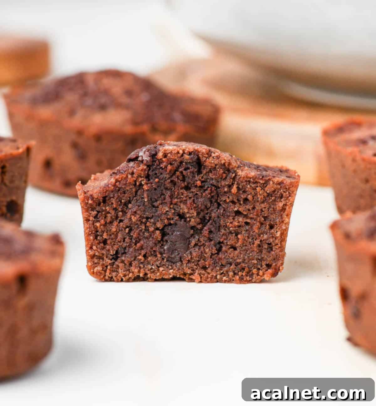 Decadent Chocolate Financiers 7 A chocolate financier sliced in half, revealing its moist and tender crumb with visible chocolate chunks inside.