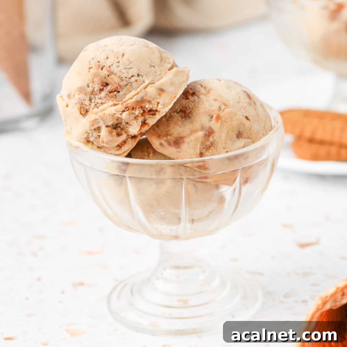 Close up on 3 scoops of ice cream in a glass dessert cup.