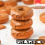 Stack of three Biscoff donuts, beautifully glazed and topped with cookie crumbs.