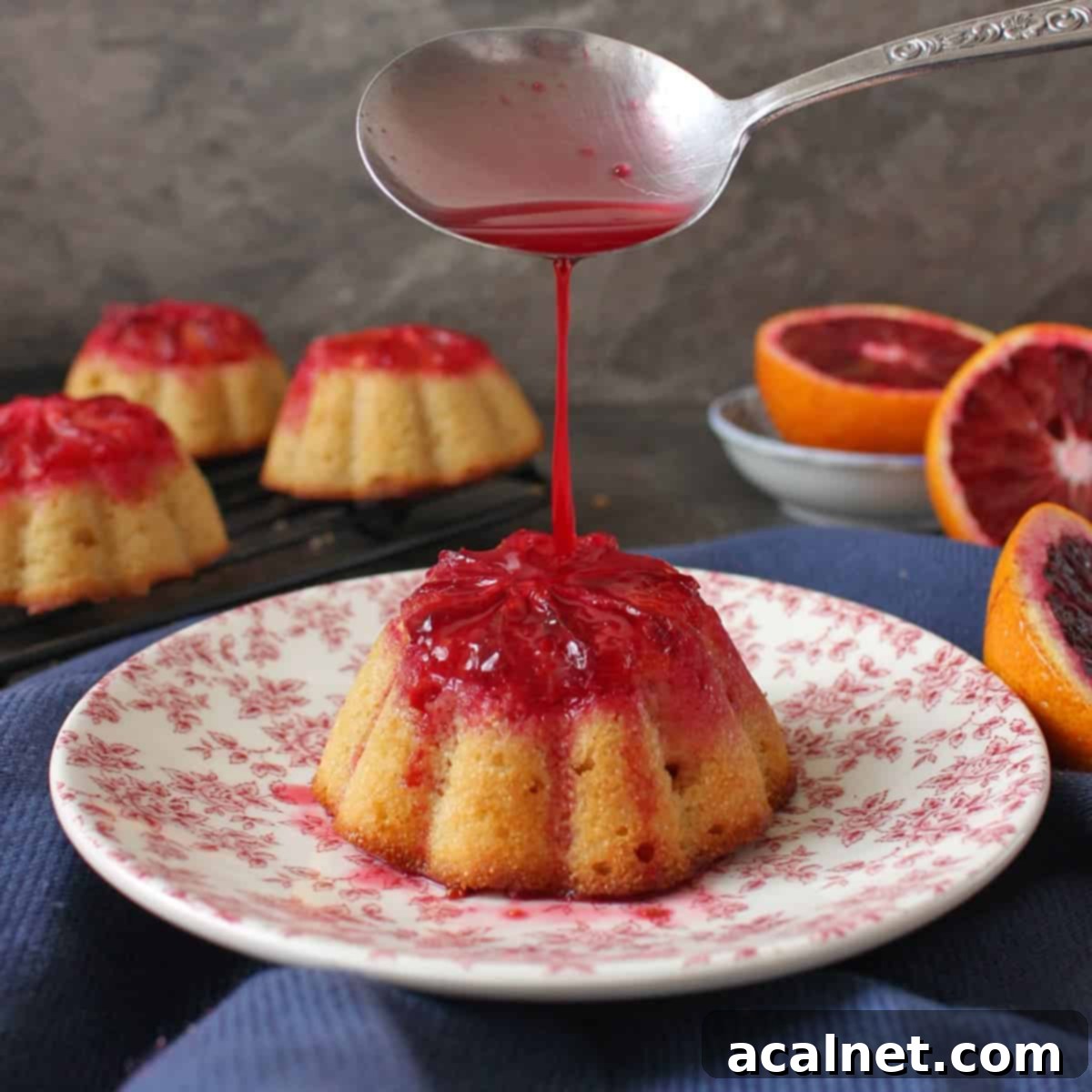 One cake on a pink plate with blood orange juice poured over.