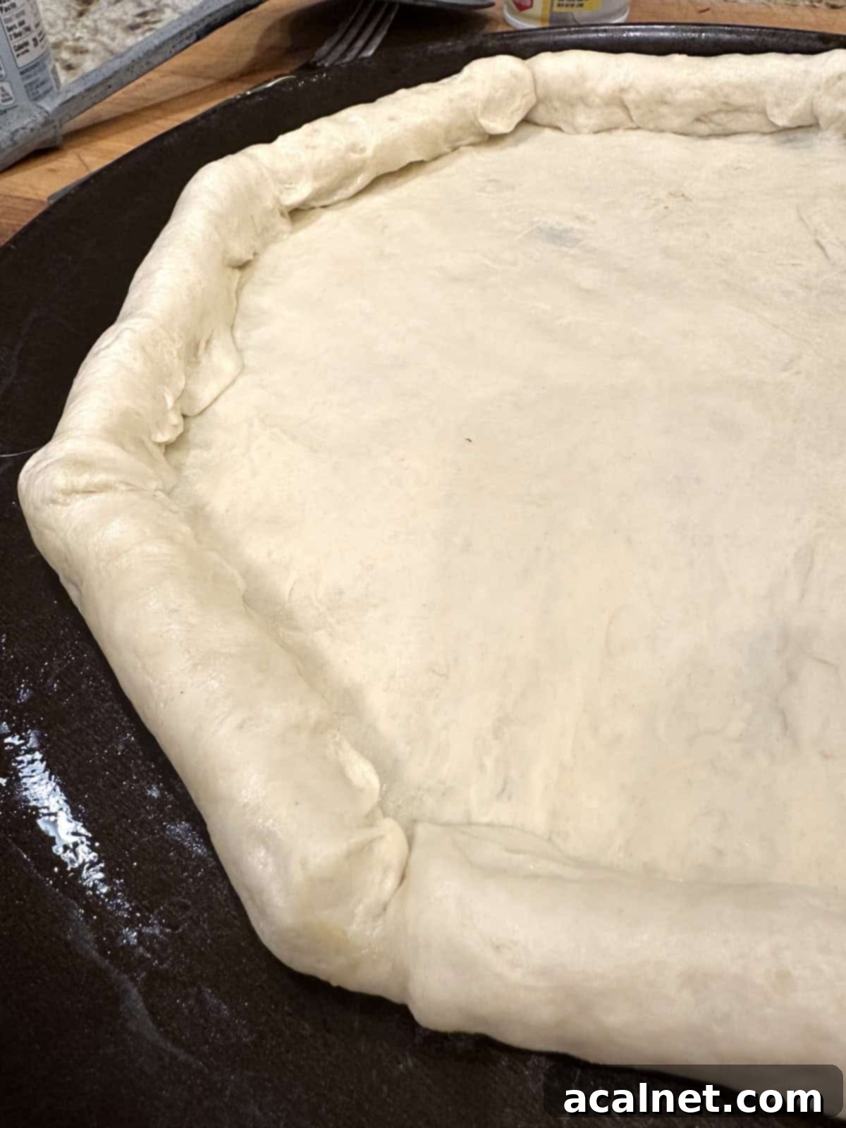 Pizza dough on a pan, with stuffed crust.