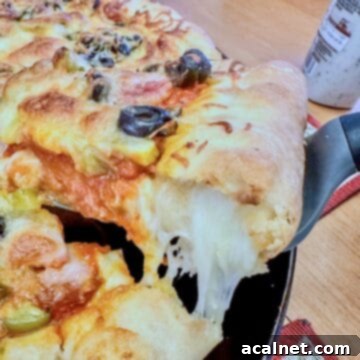 A serving a cheese-stuffed pizza being scooped up,