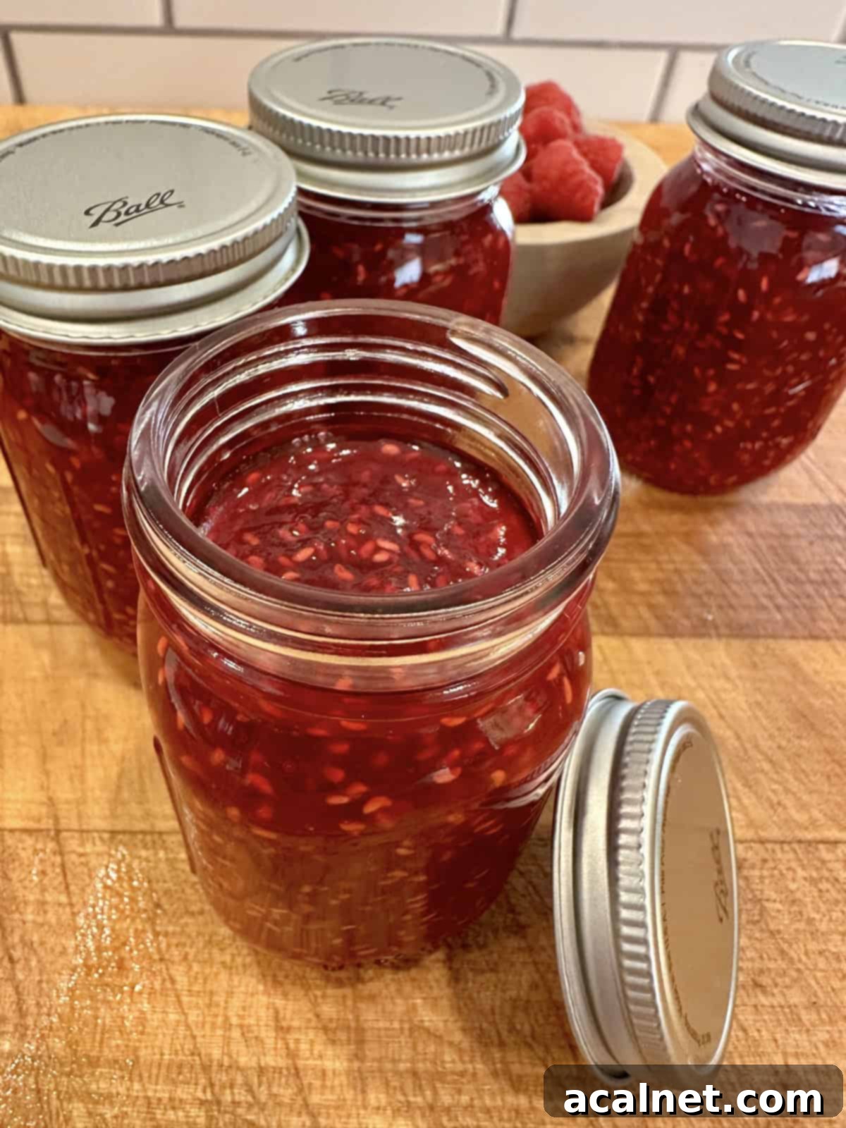Easy small batch raspberry jam in jars with lids.