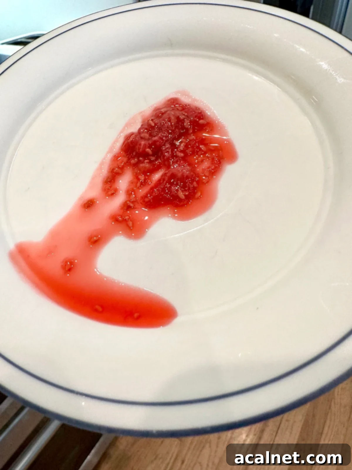 A raspberry jam on a cold plate with liquid.