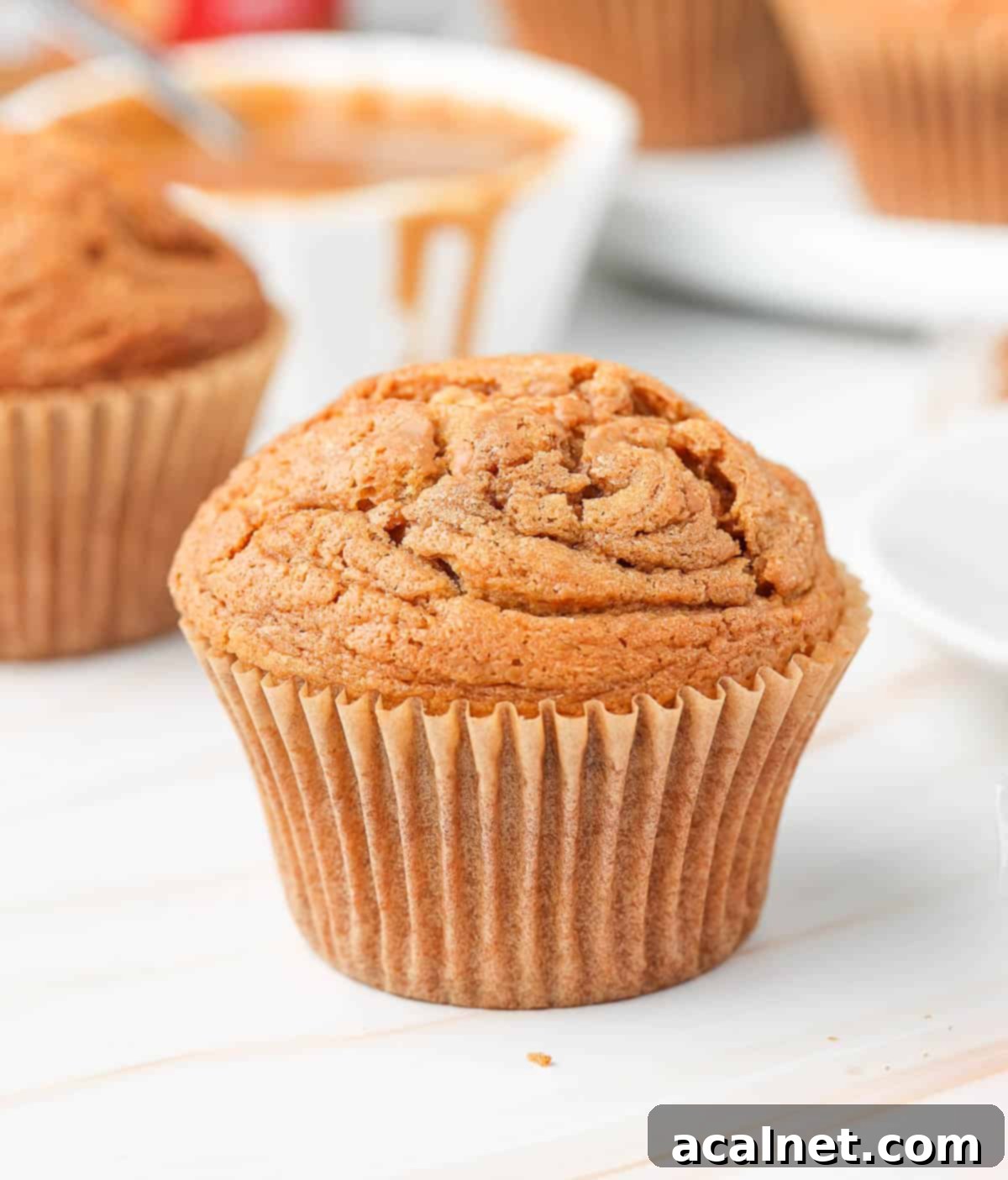 Close up on one muffin on a beige surface.